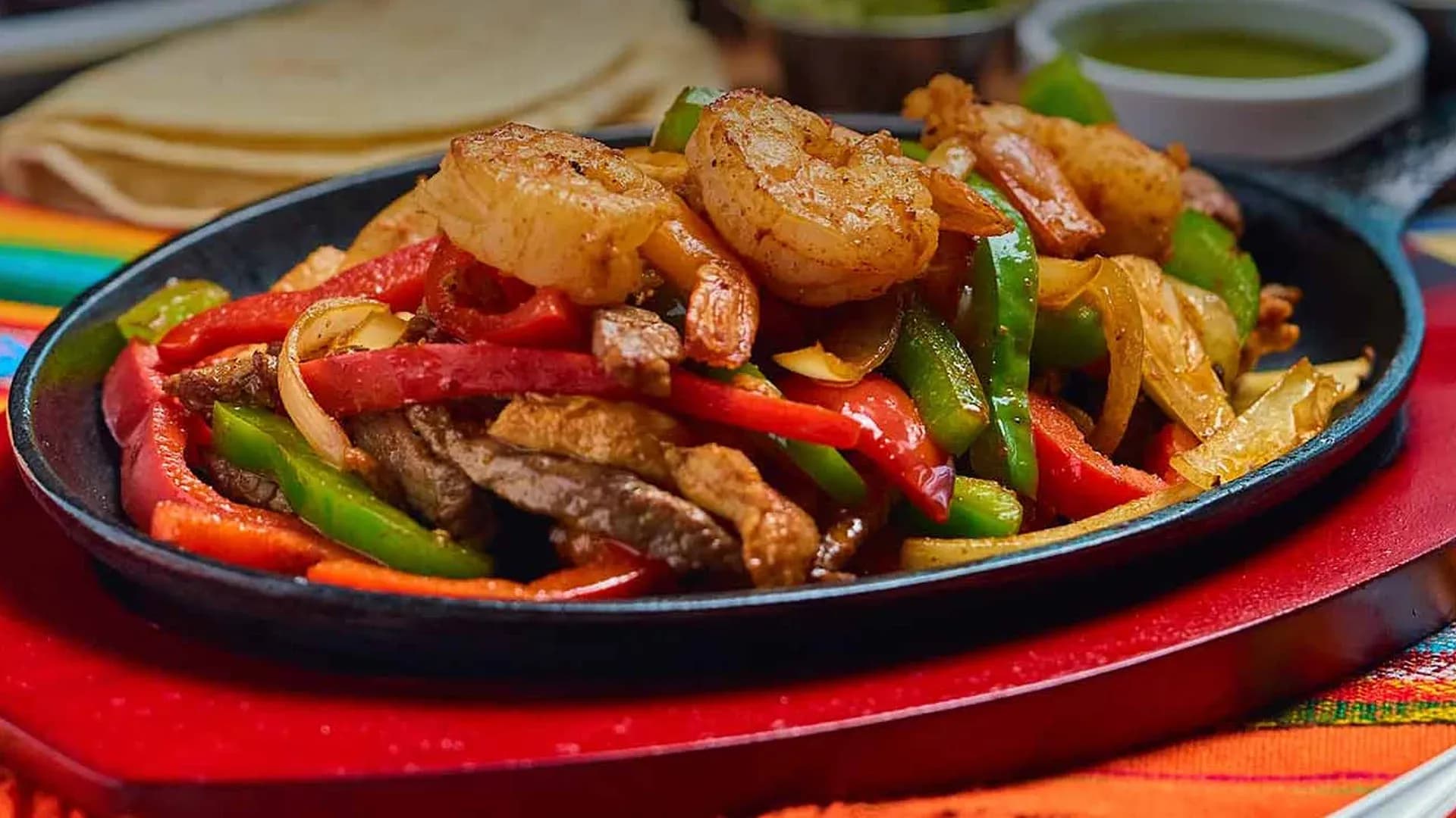 Shrimp and steak fajitas on a sizzling skillet at El Maguey